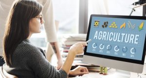 Woman Pointing At Computer Screen That Reads "Agriculture"