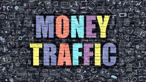 Brick Wall With "Money Traffic" Painted On In Multi-Colored Paint