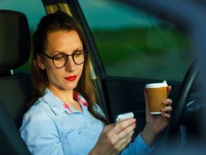 Business Woman Texting And Drinking Coffee In Self-Driving Car